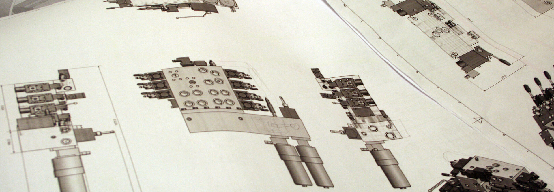 Image of multiple technical drawings on paper, displaying detailed specifications and design.