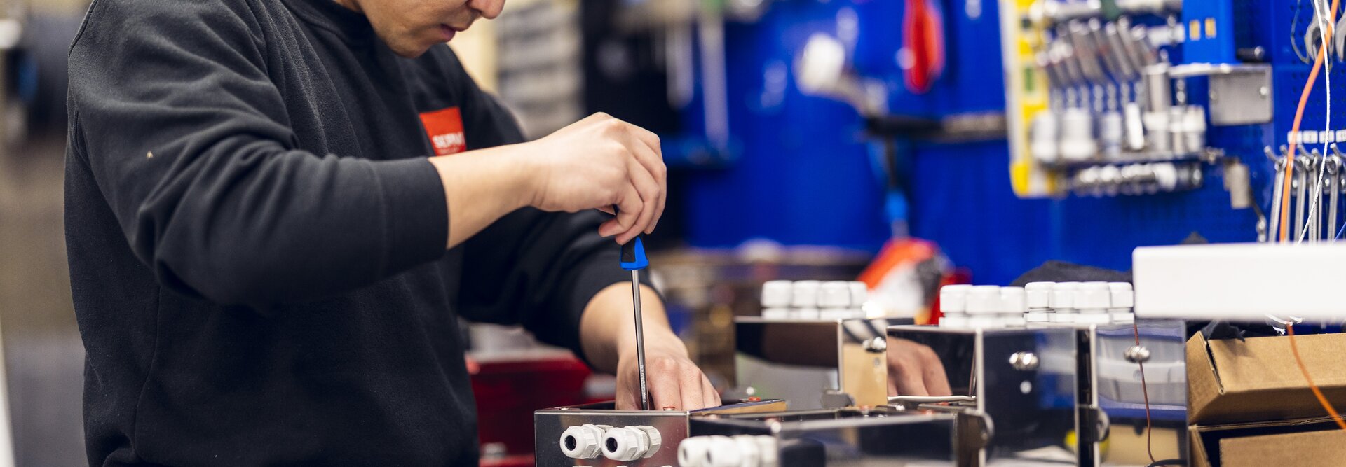 A technician from Servi is seen installing and fine-tuning an electrical and control system in an industrial setting, demonstrating precision and expertise. | © Øyvind Welle