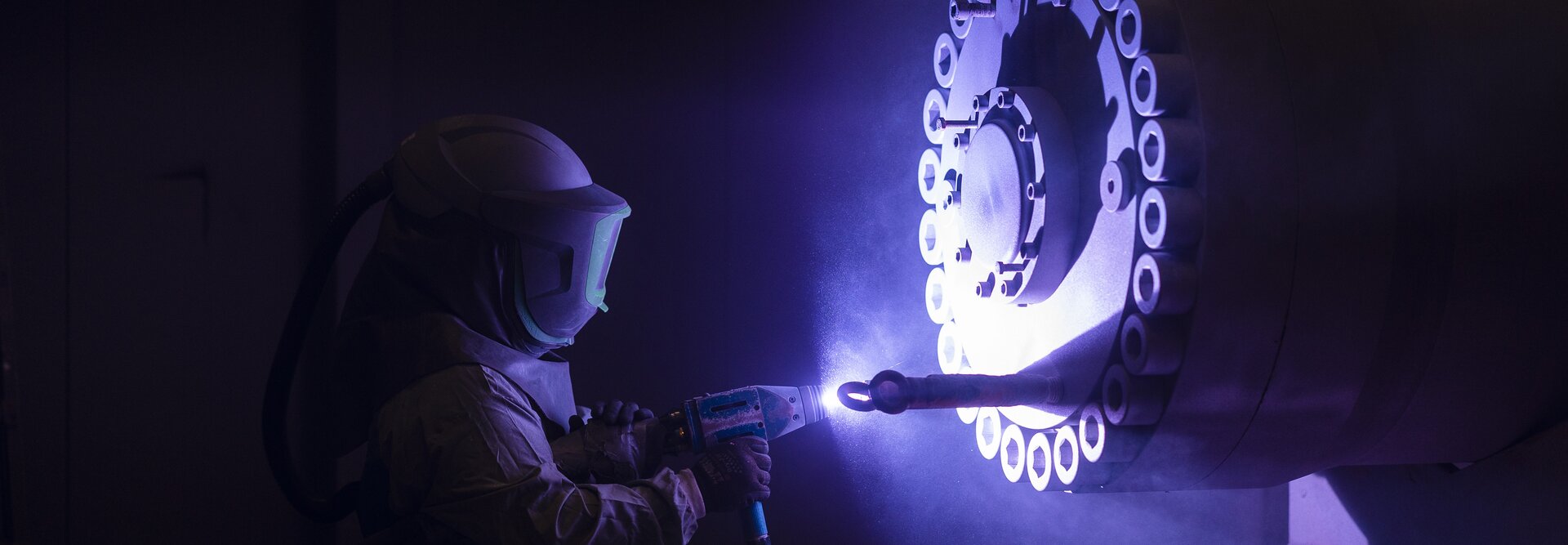 Person metal cleaning a cylinder