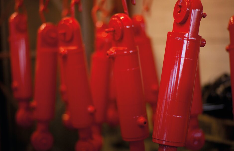 Red CD25 cylinders hanging after having been painted