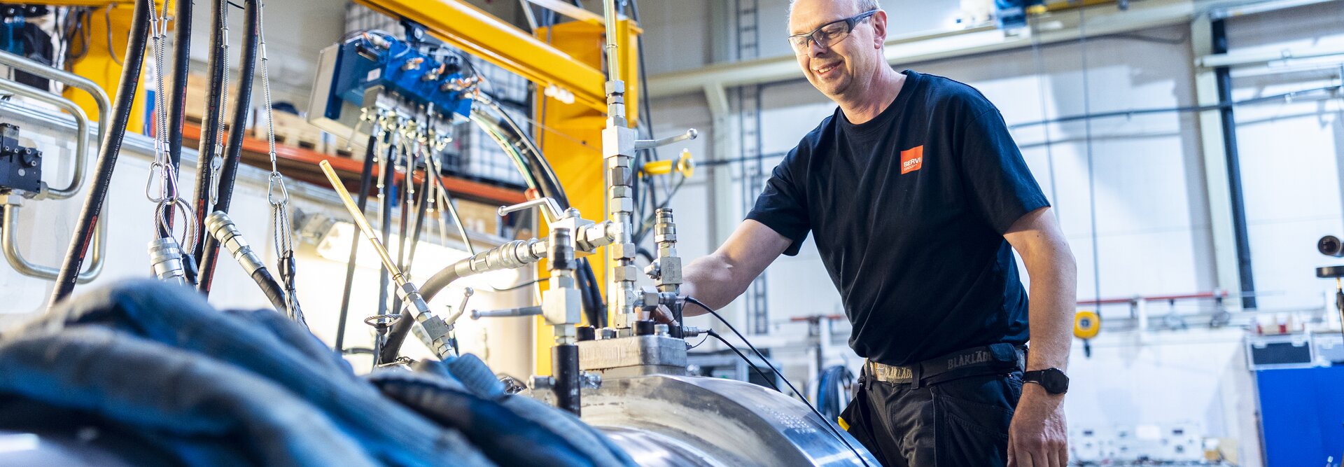 Image of a production worker at the cylinder factory in Rissa standing over a cylinder ready for pressure testing.