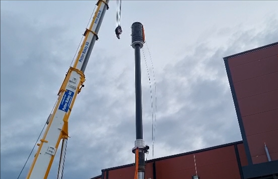 Crane pointing high up the sky to test a big cylinder