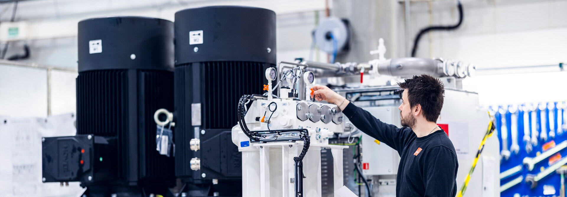A person working on a hydraulic power unit in the workshop